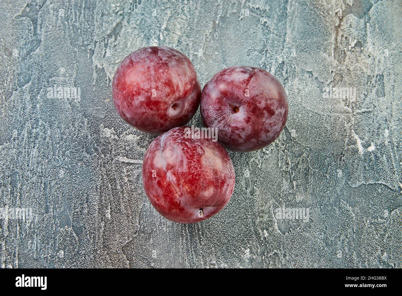 Frische Pflaumen auf blauem Hintergrund. Hintergrund von schönen Pflaumen Stockfoto