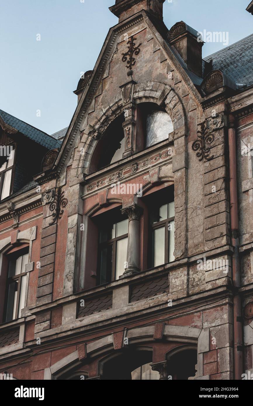 Altes Jugendstilgebäude mit Wanddekor. Rote Hauswand an einem sonnigen Tag. Riga, Lettland, Januar 2022 Stockfoto