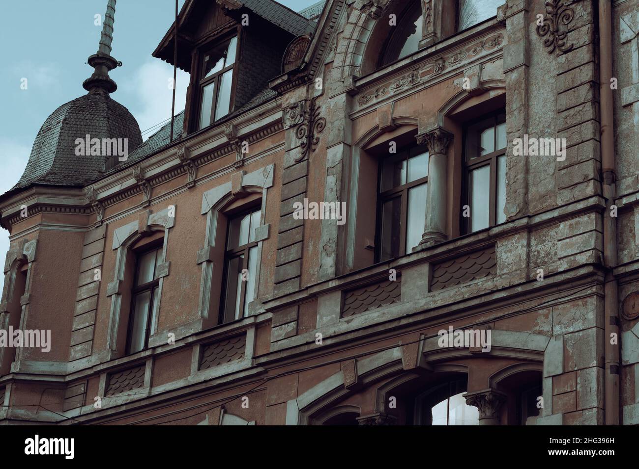 Altes Jugendstilgebäude mit Wanddekor. Rote Hauswand an einem sonnigen Tag. Riga, Lettland, Januar 2022 Stockfoto