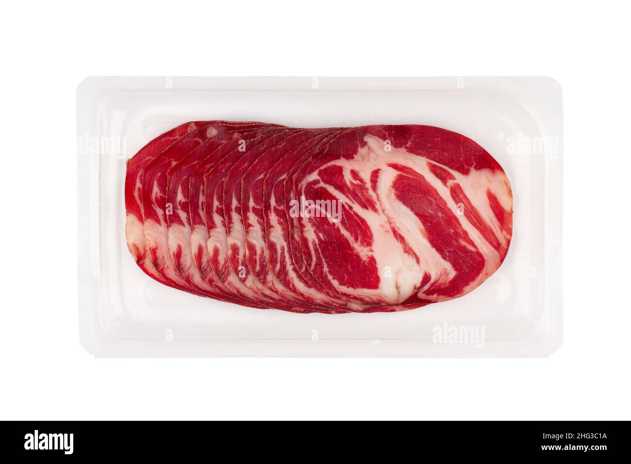 Draufsicht auf Scheiben geräucherter Schweinelende mit roter Farbe und Fett in transparenter Kunststoffverpackung isoliert auf weißem Hintergrund Stockfoto