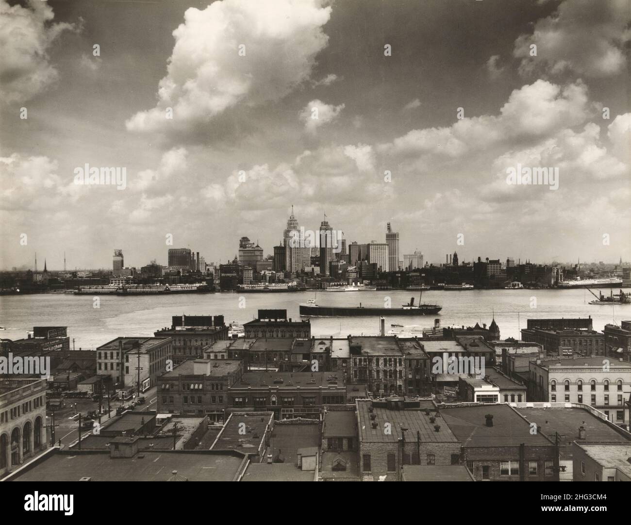 Vintage-Foto der Skyline von Detroit. Skyline von Detroit und Boote auf dem Detroit River aus Sicht von Windsor, Ontario(?). Im Vordergrund, Dächer des Gebäudes Stockfoto