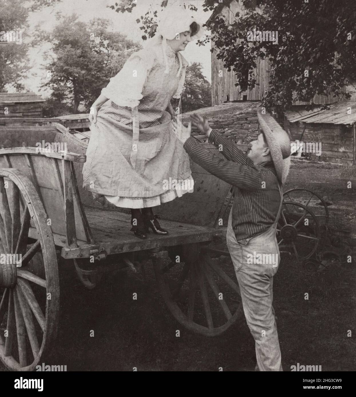 Vintage-Foto von Verliebten. „Catch Me Tom!“. USA. 1906 Frau, die kurz vor dem Sprung vom Wagen in die Arme eines Bauern steht. Stockfoto