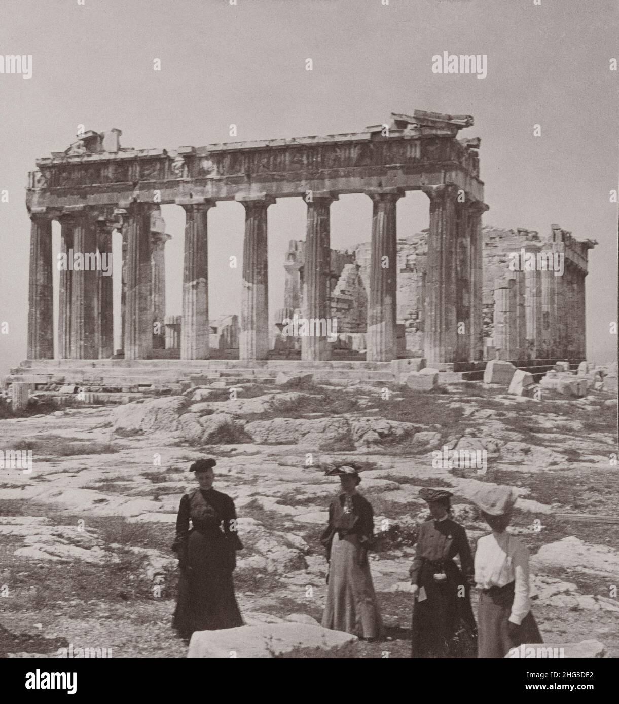 Vintage-Foto des berühmtesten klassischen Tempels der Welt, dem Parthenon in Athen, Griechenland. Das Foto von 1907 zeigt eine Gruppe von Frauen, die mit dem stehen Stockfoto