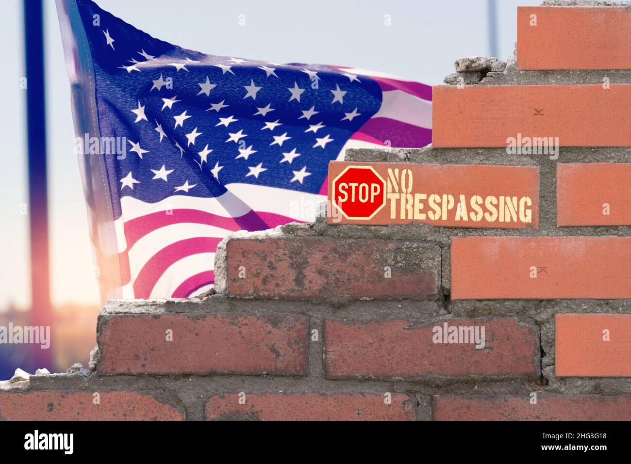 Flagge Amerikas, eine Ziegelmauer und Warnung vor der Einreise in die USA Stockfoto