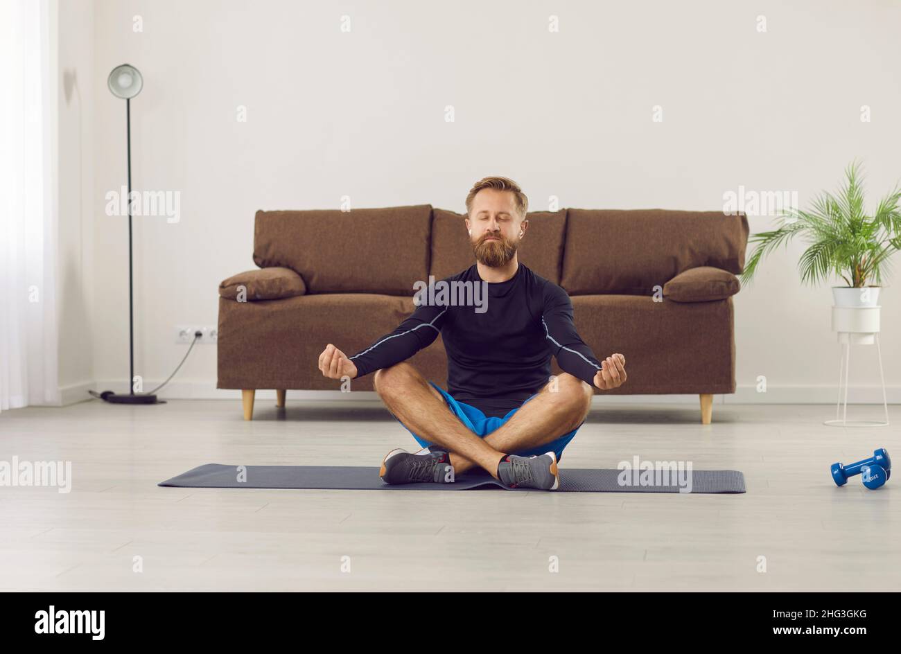 Ruhiger Mann Yoga üben zu Hause meditieren Stockfoto