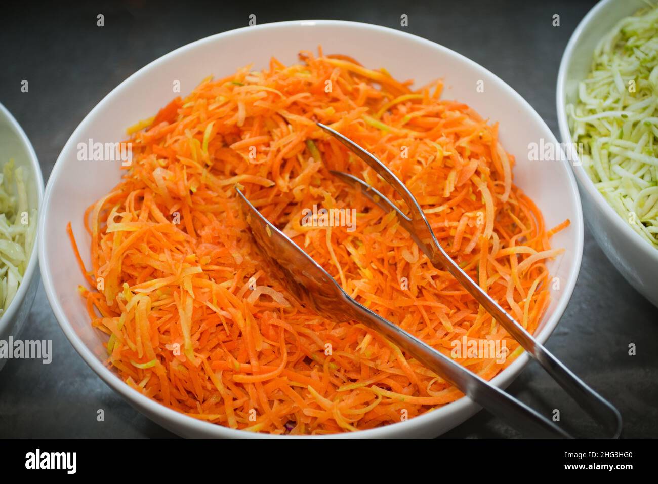 Geriebene Karottenschüssel auf einem Tisch Stockfoto