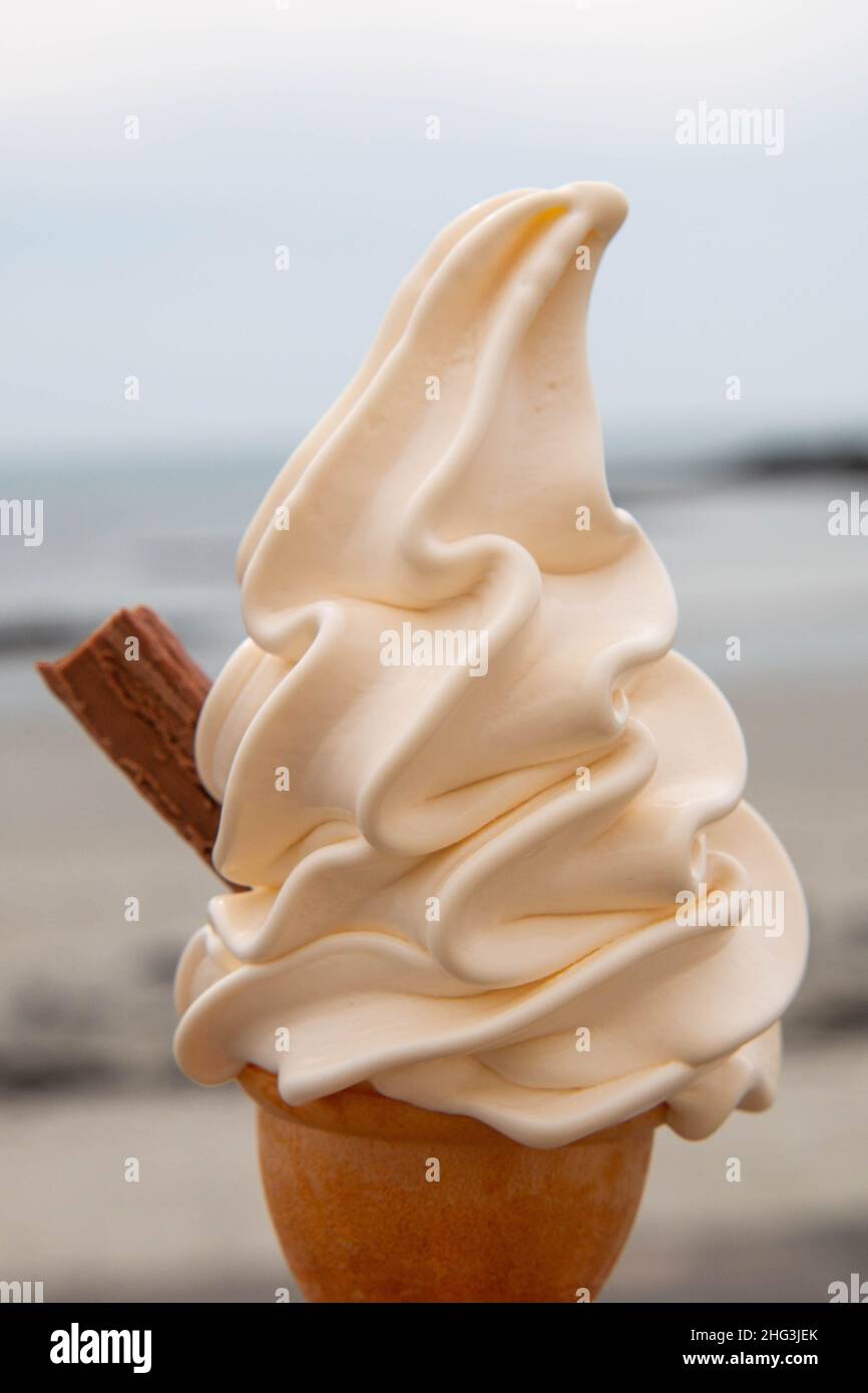 Ein Soft-Serve-Eis mit einer Schokoladenflocke, die an einem Sommertag an einem Strand in Guernsey, Channel Islands, aufgenommen wurde Stockfoto
