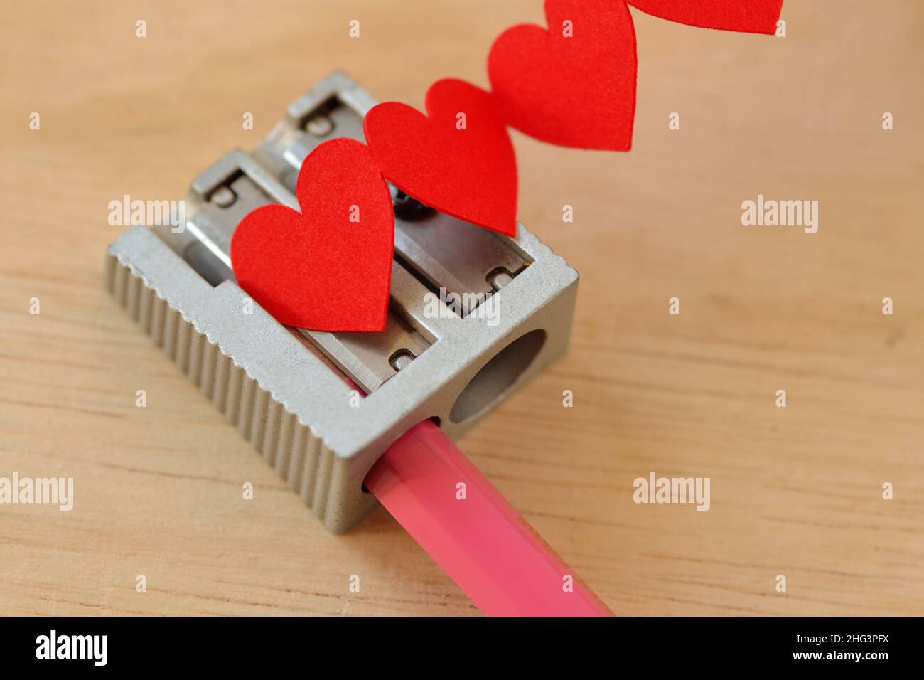 Spitzer und rosa Bleistift mit Herzkette - Konzept der Liebe Stockfoto