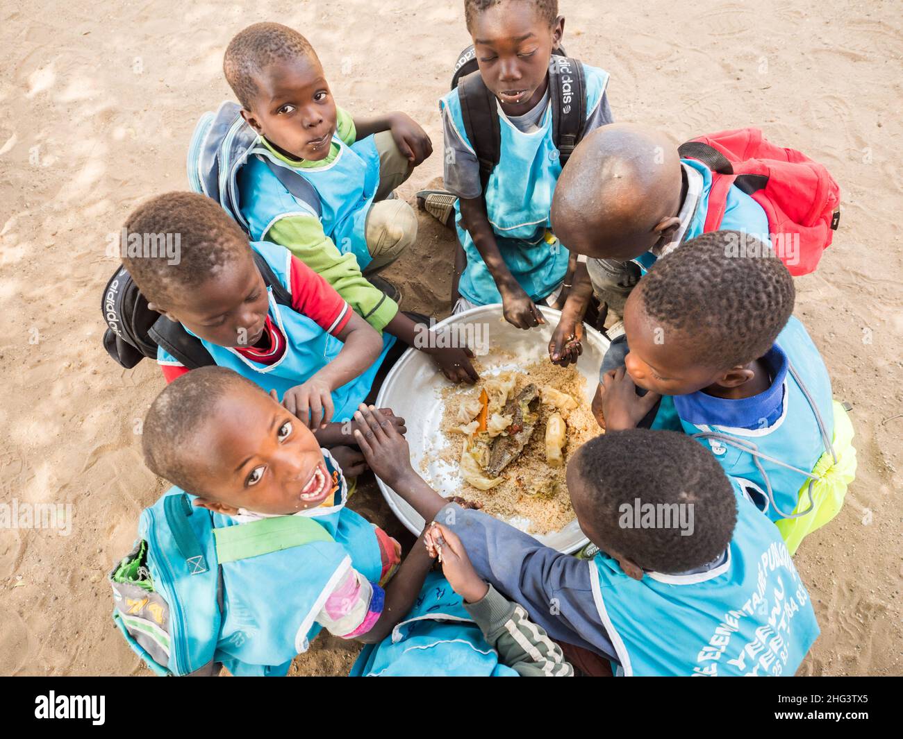 Senegal, Afrika - Jan 2019: Senegalesische Kinder essen in der Schule gemeinsam auf traditionelle Weise. Stockfoto