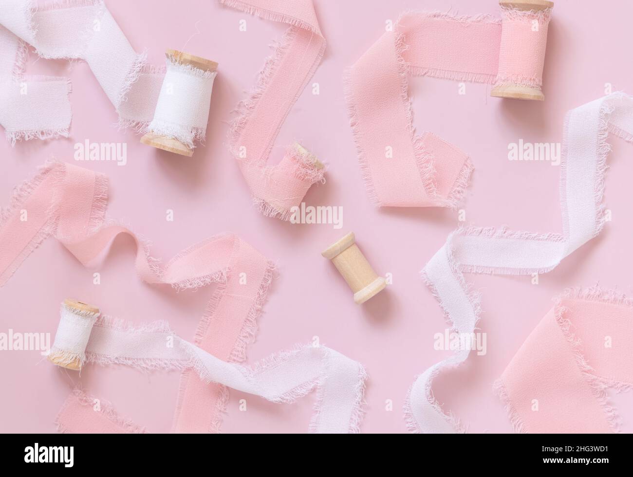 Rosa und weiße Seidenbänder auf hellrosa Draufsicht. Romantische Szene für Valentinstag, Hochzeit und girly Hintergründe flach legen Stockfoto