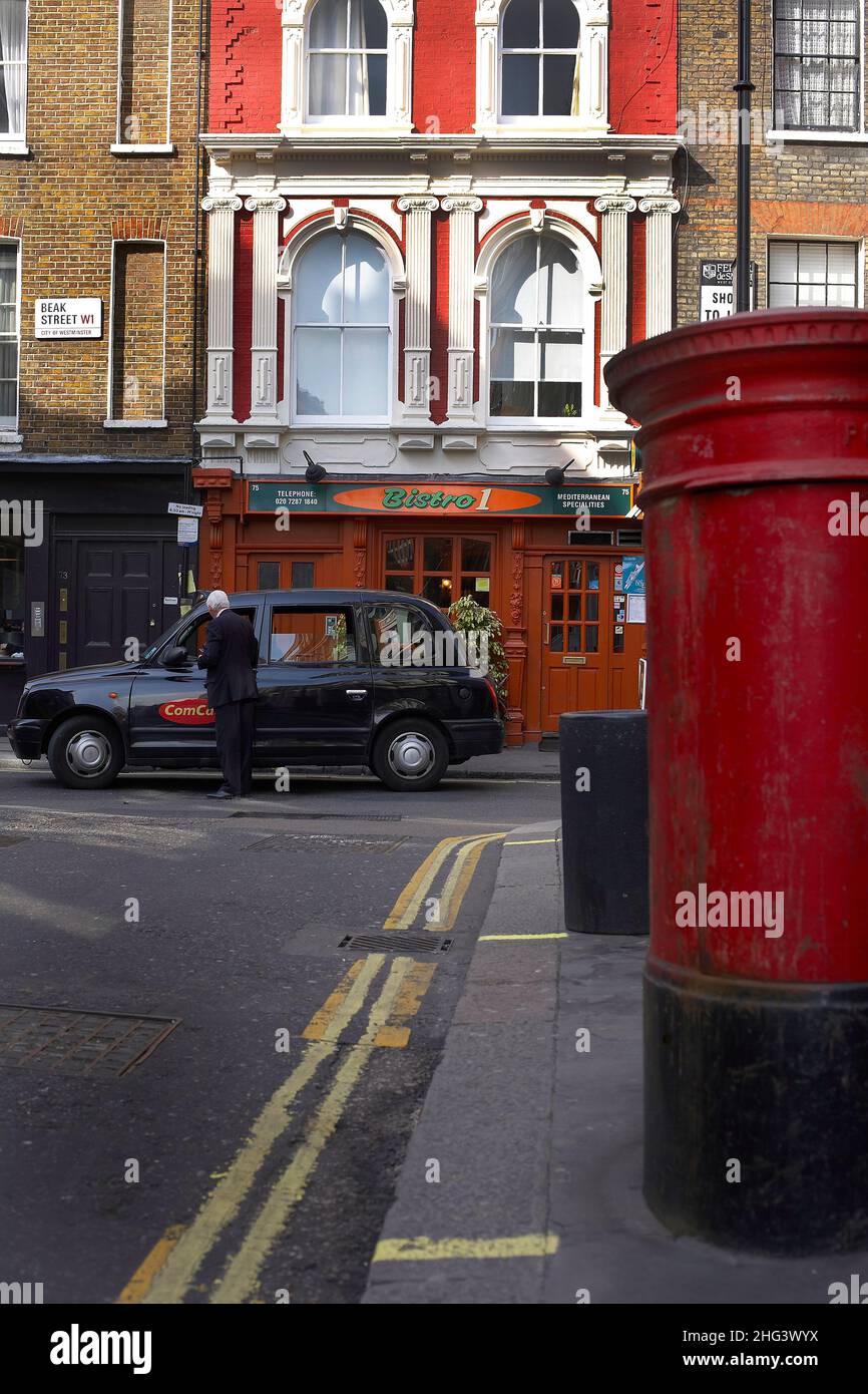 Mann, der ein Londoner Taxi in Soho, London, bezahlt Stockfoto