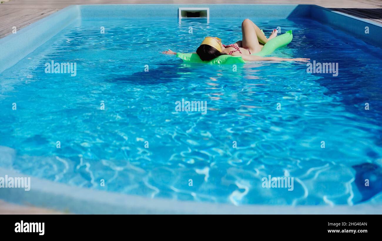 Junge Frau, die im Pool schwimmt, schwimmt im blauen Wasser Stockfoto
