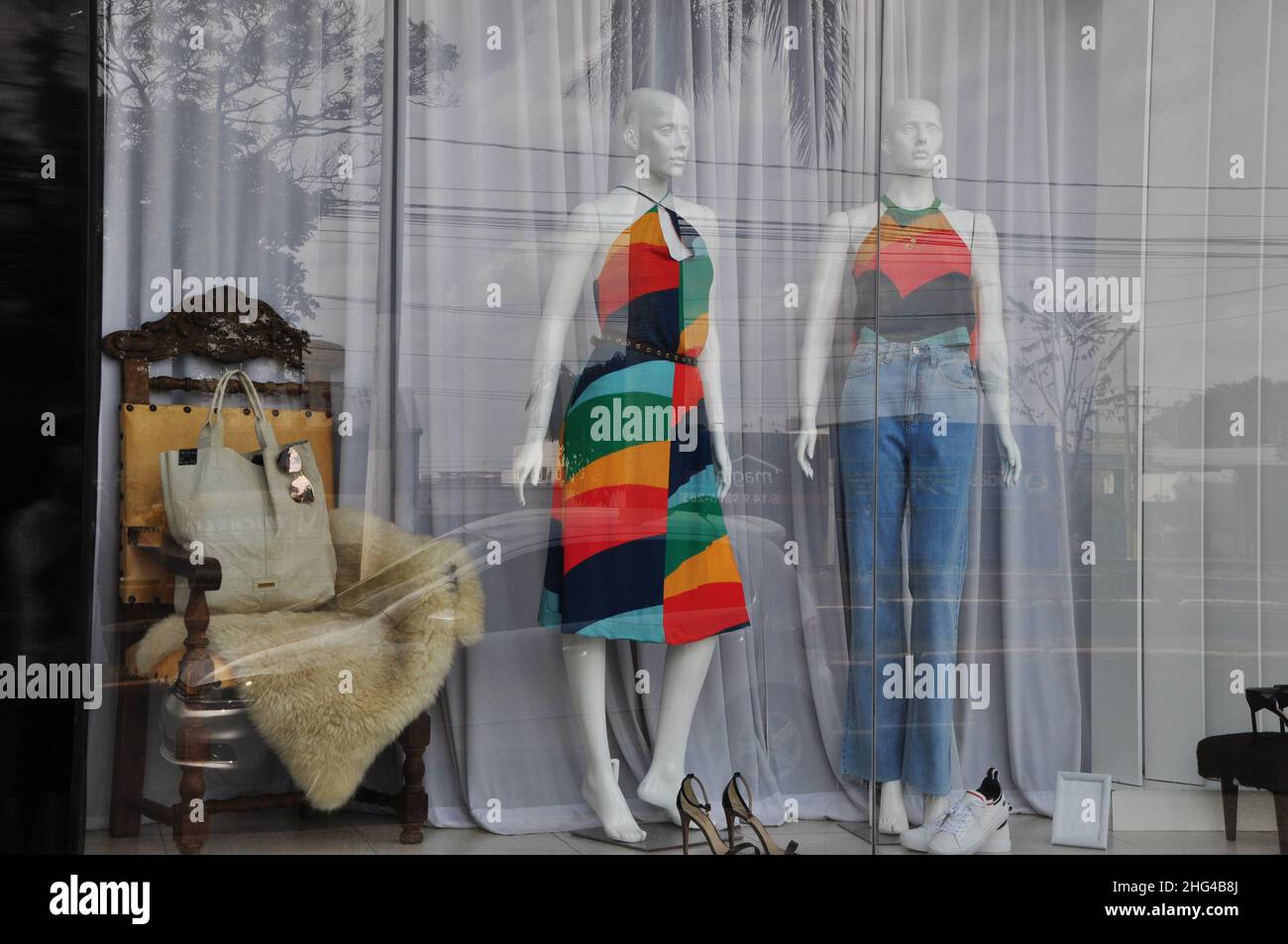 Weibliche Schaufensterpuppen mit Kleid in Hosen mit floralen Motiven, im tropischen Stil, brasilianische Mode, in einem Schaufenster mit Accessoires und Objekten, in Braz Stockfoto