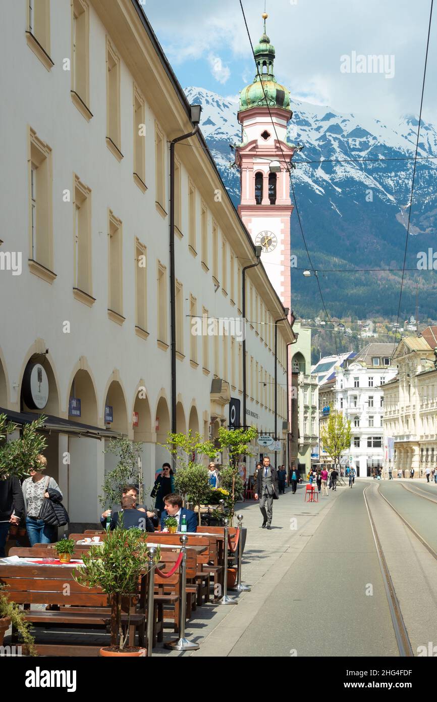 Innsbruck, Österreich - April 17th 2021: Lebhafte Straße mit Restaurant im historischen Stadtzentrum. Stockfoto