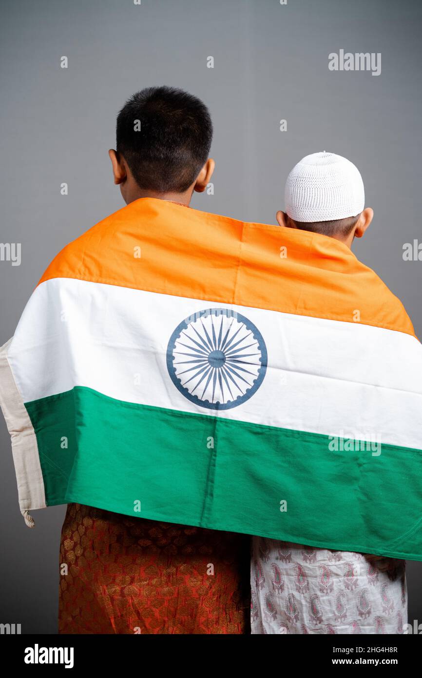 Rückansicht der indischen Kinderflagge auf multireligiöser Kinderschulter auf grauem Hintergrund - Konzept der Freiheit, Freundschaft, Einheit in Vielfalt, Nationalismus und Stockfoto