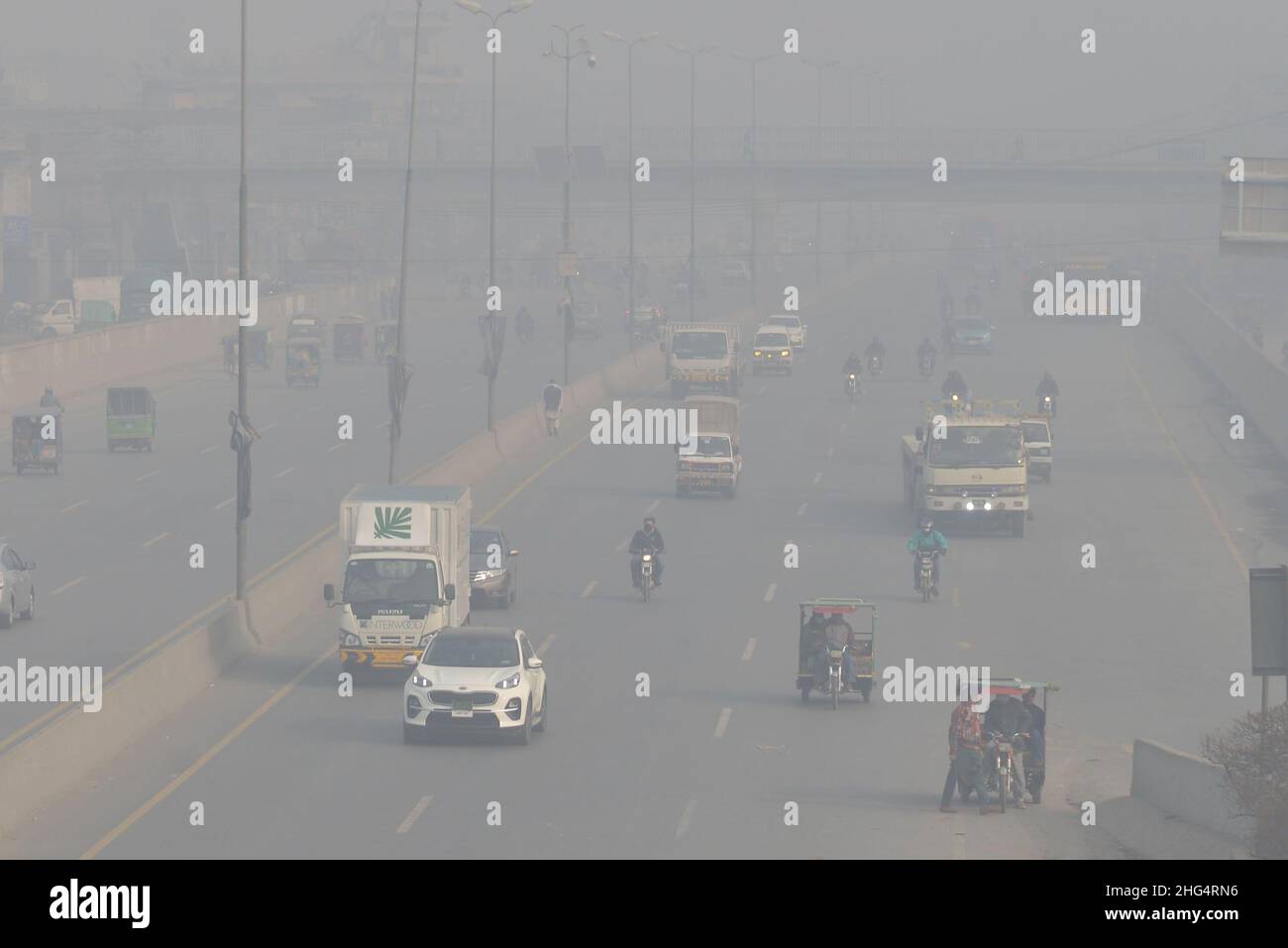 Lahore, Pakistan. 13th Januar 2022. Pakistanische Bürger sind am 13. Januar 2022 durch dicke Smog-Decke in Lahore auf dem Weg zur Band Road. Pakistanische Bewohner und Pendler sind besorgt wegen der dichten Nebelschicht, die Probleme bei der Atmung und der Sicht verursacht und auch den reibungslosen Verkehrsfluss behindert hat. (Foto von Rana Sajid Hussain/Pacific Press/Sipa USA) Quelle: SIPA USA/Alamy Live News Stockfoto