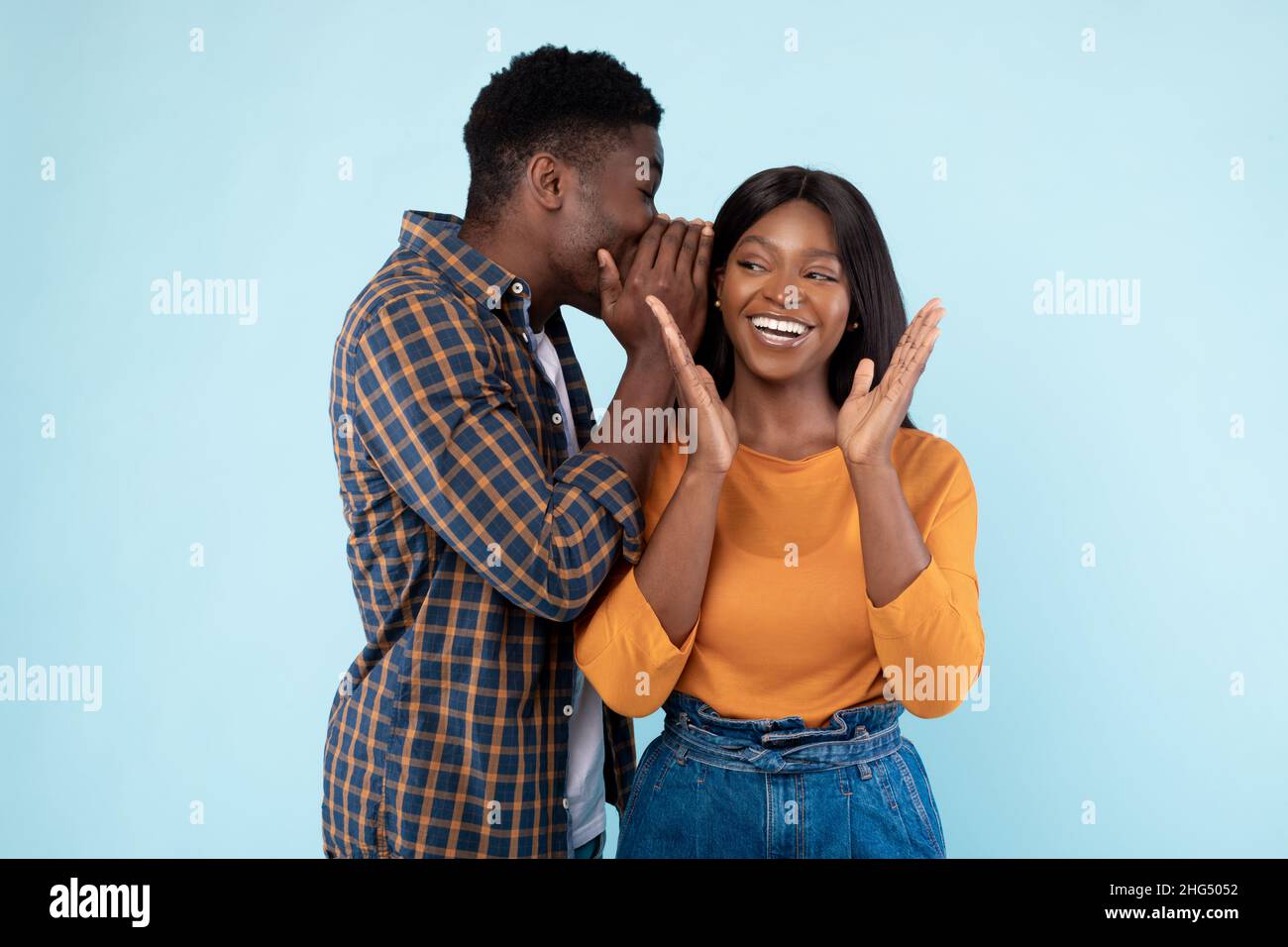 Black Man Teilen Nachrichten Mit Seiner Aufgeregt Freundin Whispering Zu Ohr Stockfoto