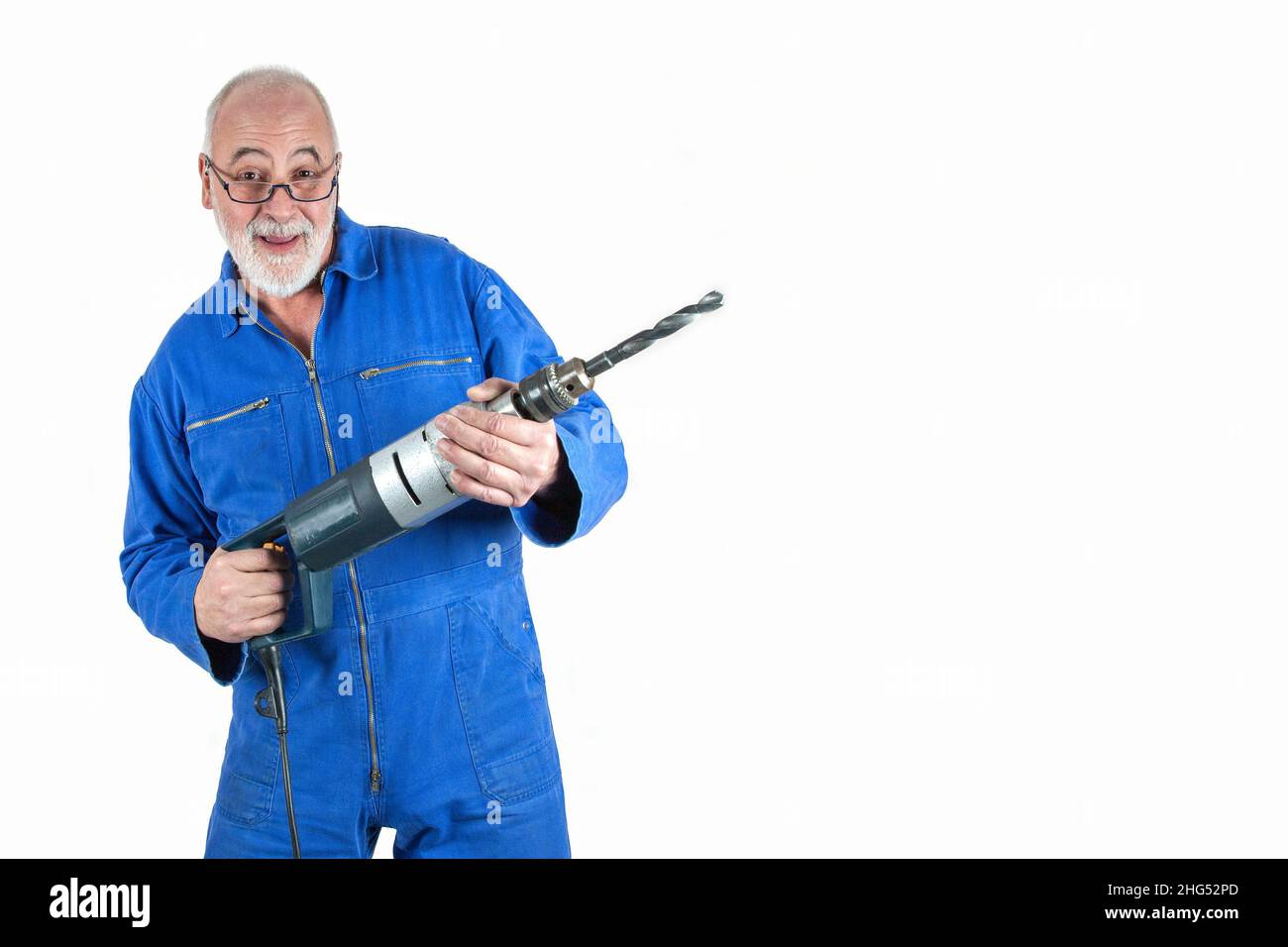 Dynamischer, älterer Handwerker mit viel Berufserfahrung hält seine Bohrmaschine mit einem dicken Bohrer in den Händen. Stockfoto