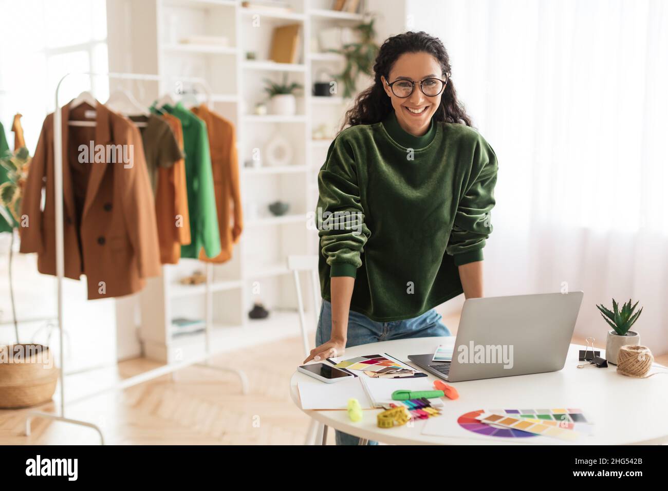 Happy Clothing Designerin Lady Mit Laptop Lächelnd Im Showroom Stehend Stockfoto