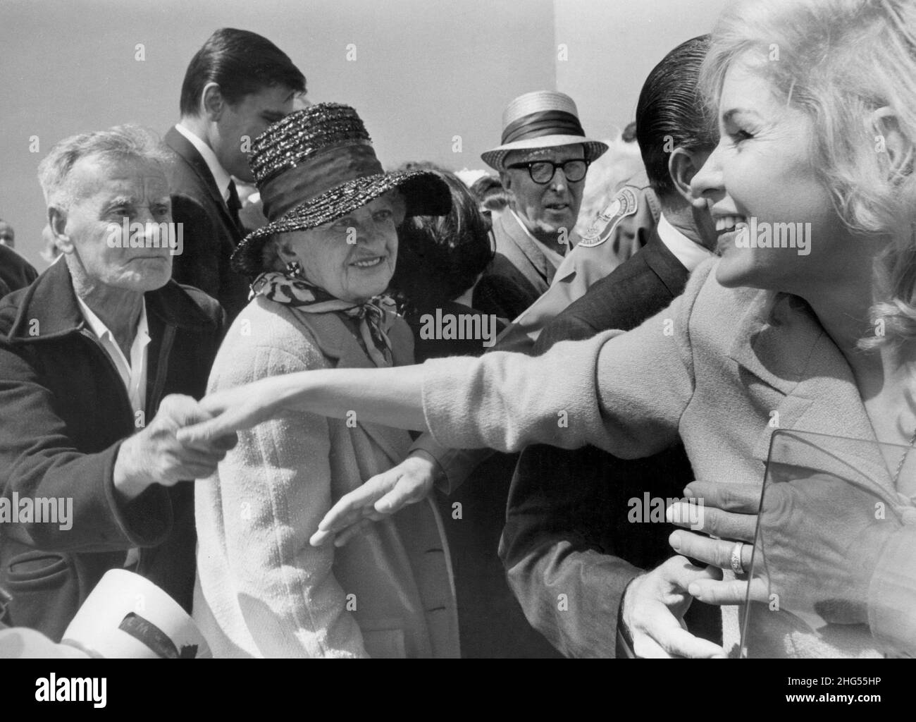 Candace Mossler und ihr Neffe Melvin Lane Powers, mit dem sie eine inzestuöse Affäre hatte, wurden am 29. Juni 1964 in seiner Eigentumswohnung in Key Biscayne, Florida, des Tötens von Mosslers Millionärsmann, Jacques Mossler, angeklagt. Nach einem weithin veröffentlichten Prozess wurden beide am 20. Juli 1965 freigesprochen, was auf diesem Foto abgebildet ist, das sie beim Ausgehen aus dem Gerichtssaal aufgenommen und über wartende Autos weggelassen haben. Hier wird sie von anbetenden Fans begrüßt, als sie sich auf die Abreise vorbereitet. Stockfoto