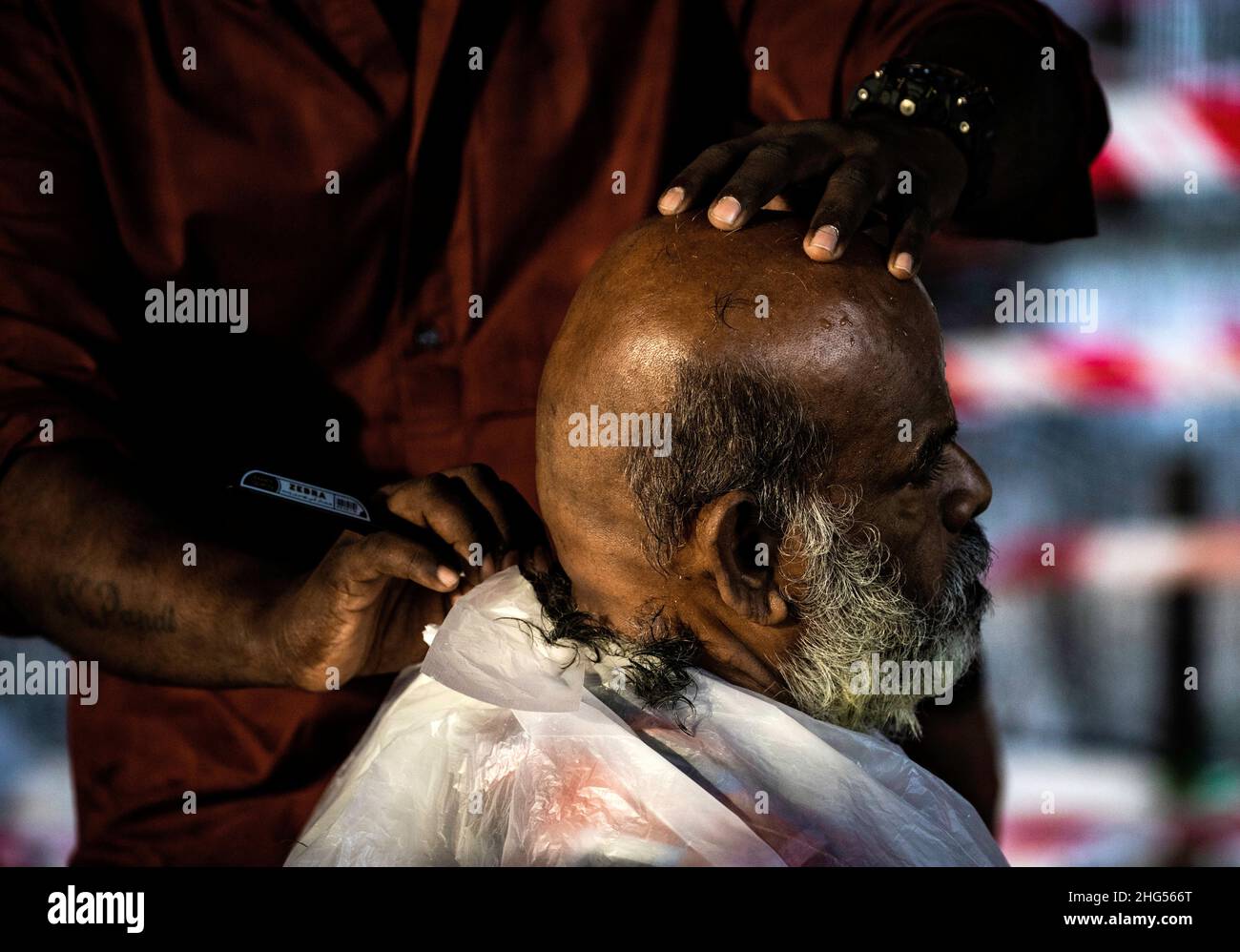 Kuala Lumpur, Malaysia. 18th Januar 2022. Ein hinduistischer Anhänger rasiert vor der Prozession während des Thaipusam-Festivals im Tempel der Batu-Höhlen den Kopf kahl.Thaipusam ist ein alljährliches Hindu-Fest, das vor allem von der tamilischen Gemeinde zu Ehren des Hindu-gottes Lord Murugan gefeiert wird. Eifrige Anhänger werden segnen und Gelübde ablegen, wenn ihre Gebete erhört werden. Kredit: SOPA Images Limited/Alamy Live Nachrichten Stockfoto