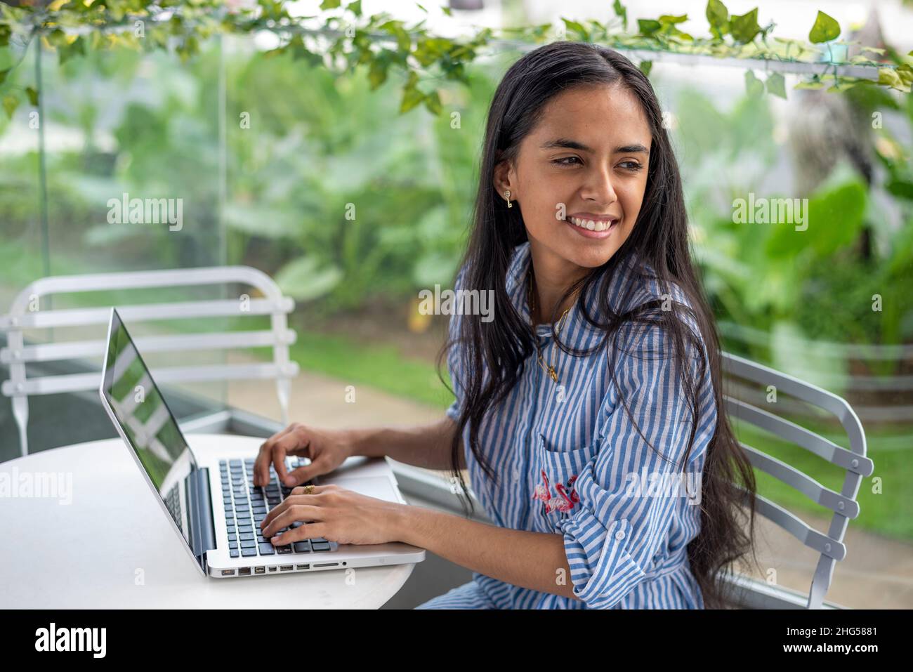 Junge Frau, die mit einem Laptop im Freien arbeitet Stockfoto