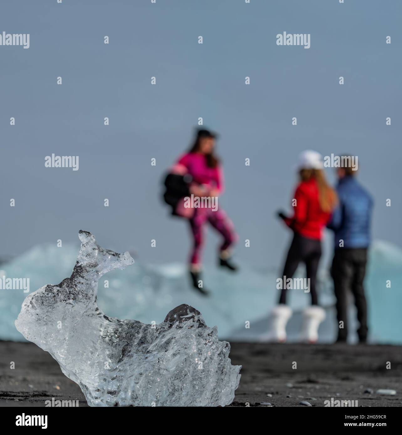 Verschwommene Touristen im Hintergrund und Eisberg im Fokus Stockfoto