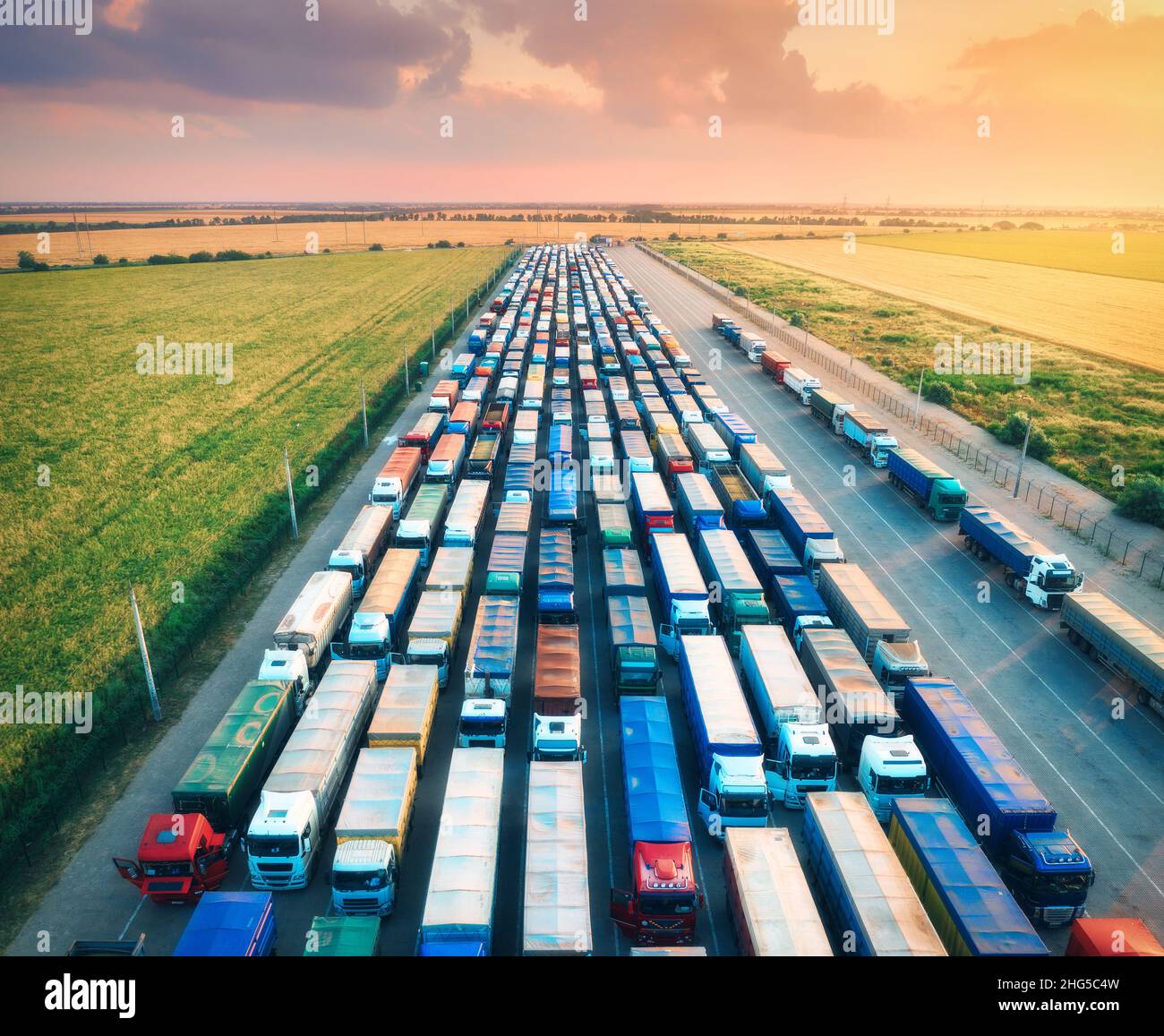 Luftaufnahme von bunten Lastwagen im Terminal bei Sonnenaufgang im Sommer Stockfoto