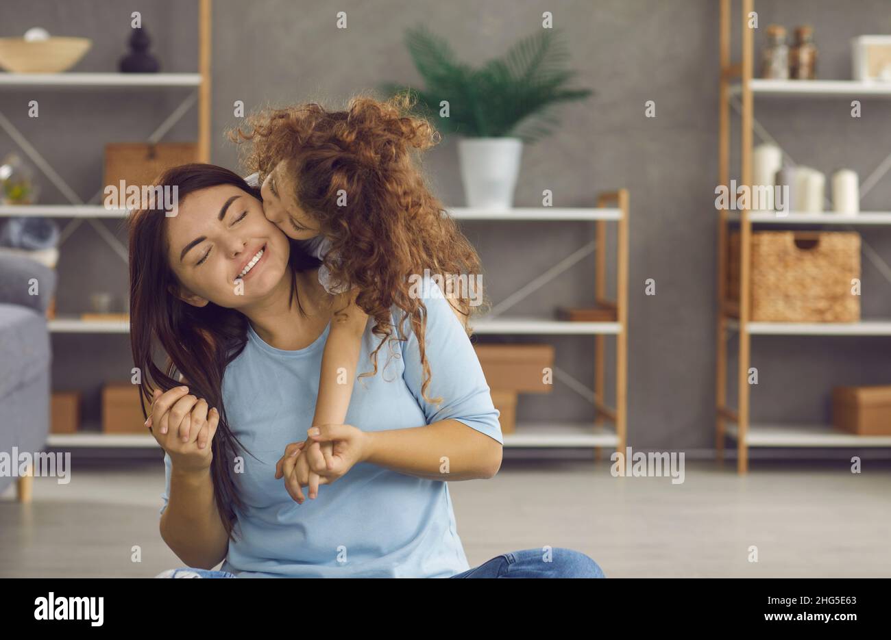Liebende kleine Tochter fühlen dankbar küssen junge Mutter Stockfoto