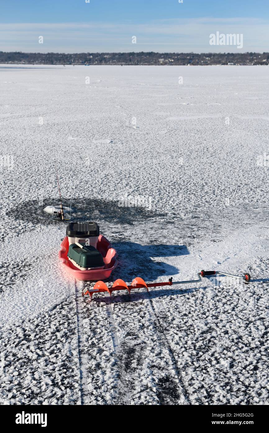 Angelrute und Schnecke zum Eisfischen auf dem ersten Eis des Winters auf der gefrorenen Kempenfelt Bay am Lake Simcoe Barrie Ontario Stockfoto