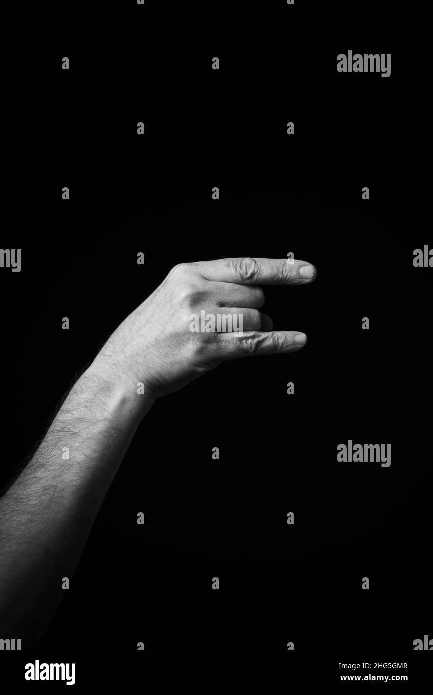 Dramatische s+W-Bild der männlichen Hand Fingerbuchstabierung CSL chinesischen Zeichen Sprache Buchstaben Z isoliert vor dunklem Hintergrund Stockfoto