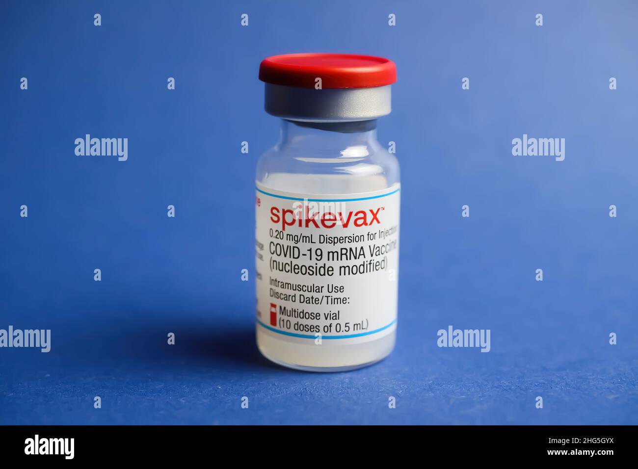 Viersen, Deutschland - Januar 9. 2022: Nahaufnahme eines isolierten mRNA-Impfserumfläschchens Moderna Spikevax, blauer Hintergrund Stockfoto