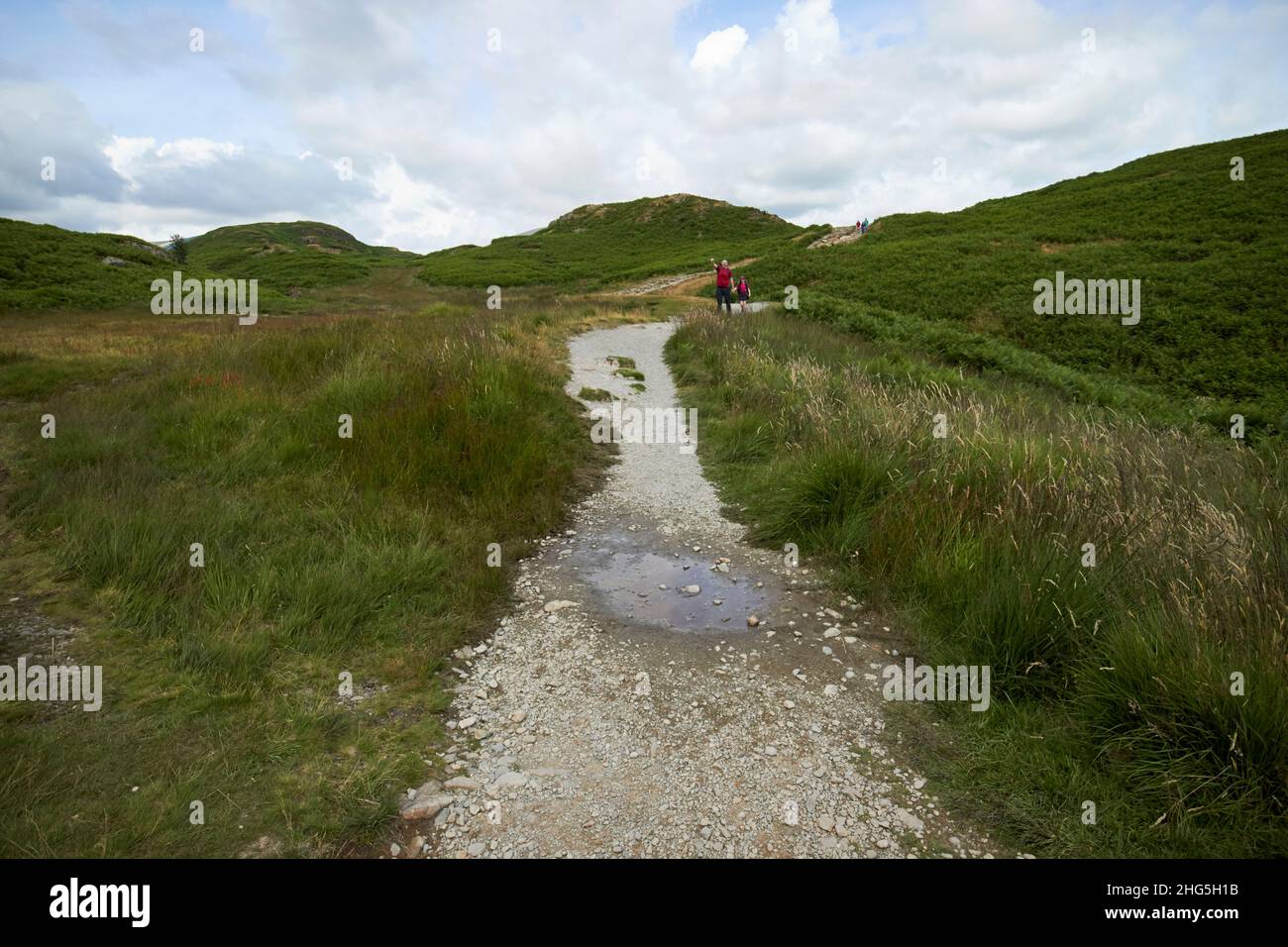 Mann und junge Mädchen wandern auf dem Weg rund um loughrigg Fell Lake District, cumbria, england, großbritannien Stockfoto
