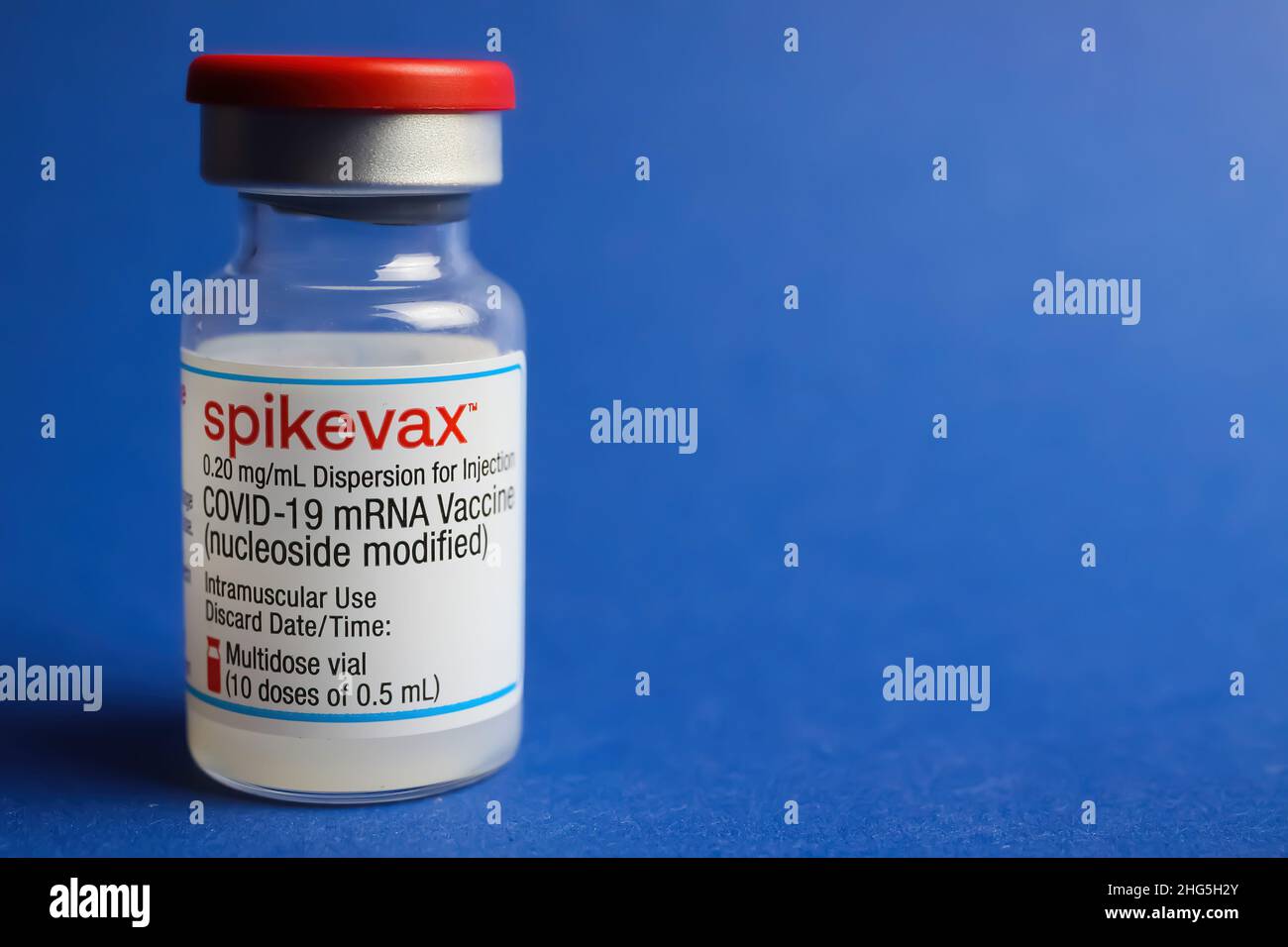 Viersen, Deutschland - Januar 9. 2022: Nahaufnahme eines isolierten mRNA-Impfserumfläschchens Moderna Spikevax, blauer Hintergrund Stockfoto