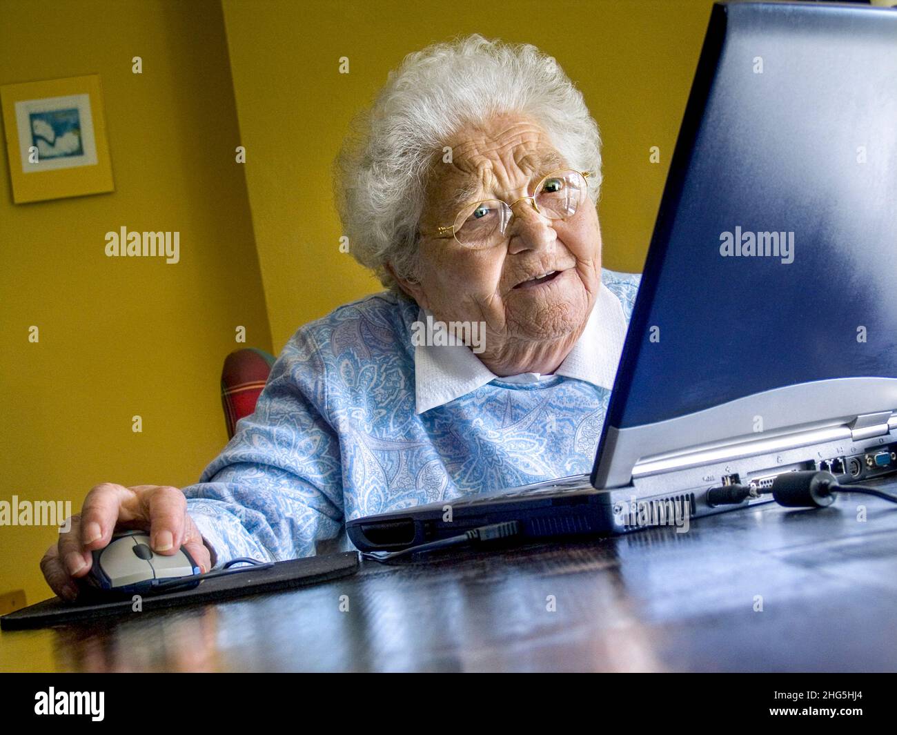 Computer ältere alte Dame im Alter von 80-85 Jahren, fasziniert und erstaunt von den neuen Computermöglichkeiten zu Hause, indem sie neue Technologien nutzt, die mit ihrem Laptop erforscht und erlernt werden. Stockfoto
