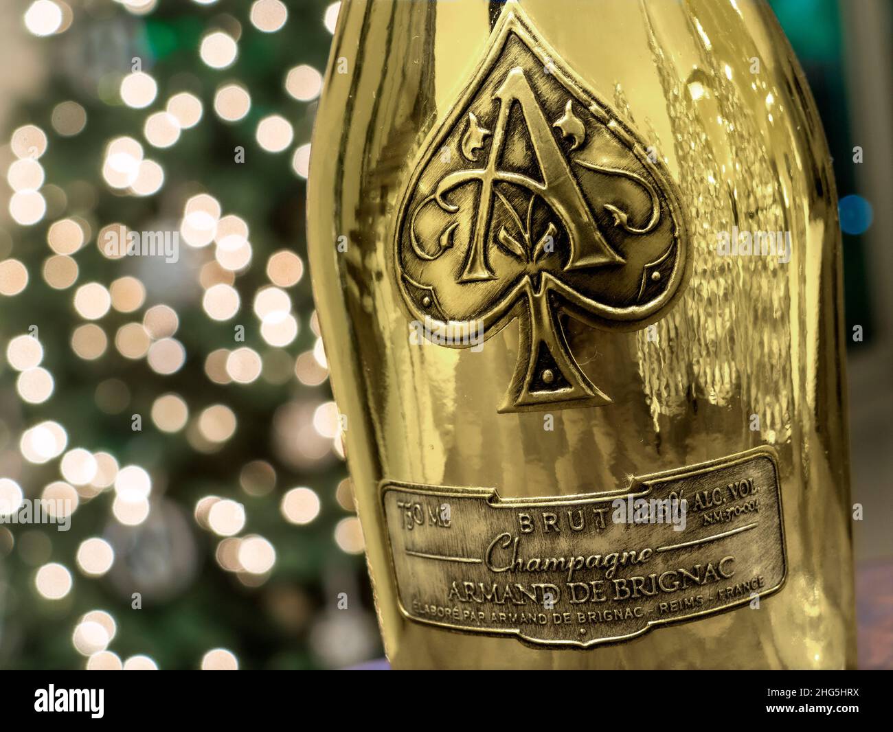 Armand de Brignac „Ace of Spades“, CHAMPAGNER, feiner Luxus, unverwechselbare Champagner-Flasche aus metallischem Gold mit funkelnden Feierlichtern dahinter Stockfoto