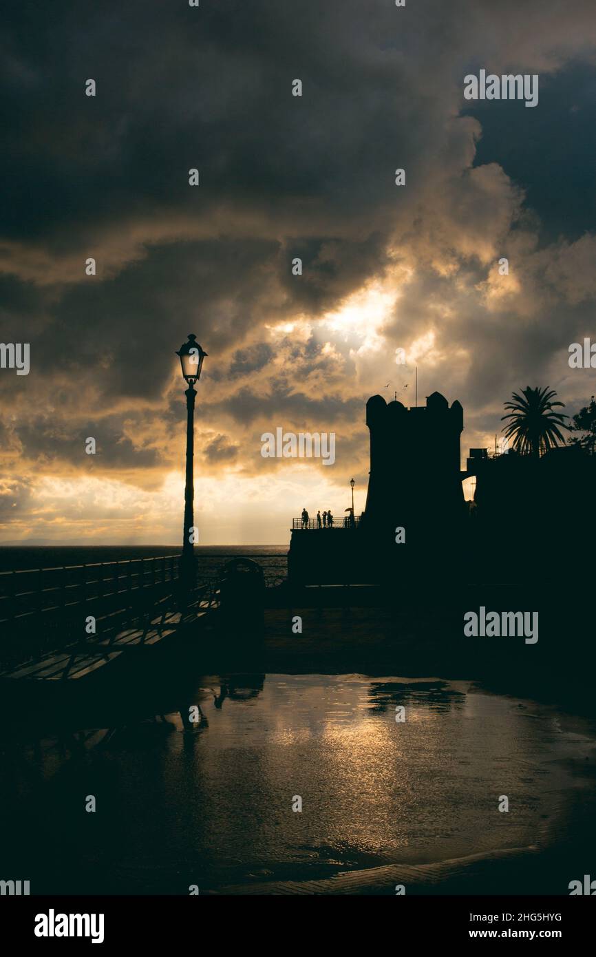 Eine Silhouette des alten Nervi-Turms, genova. Sonnenuntergang mit Wolken an einem regnerischen Tag Stockfoto