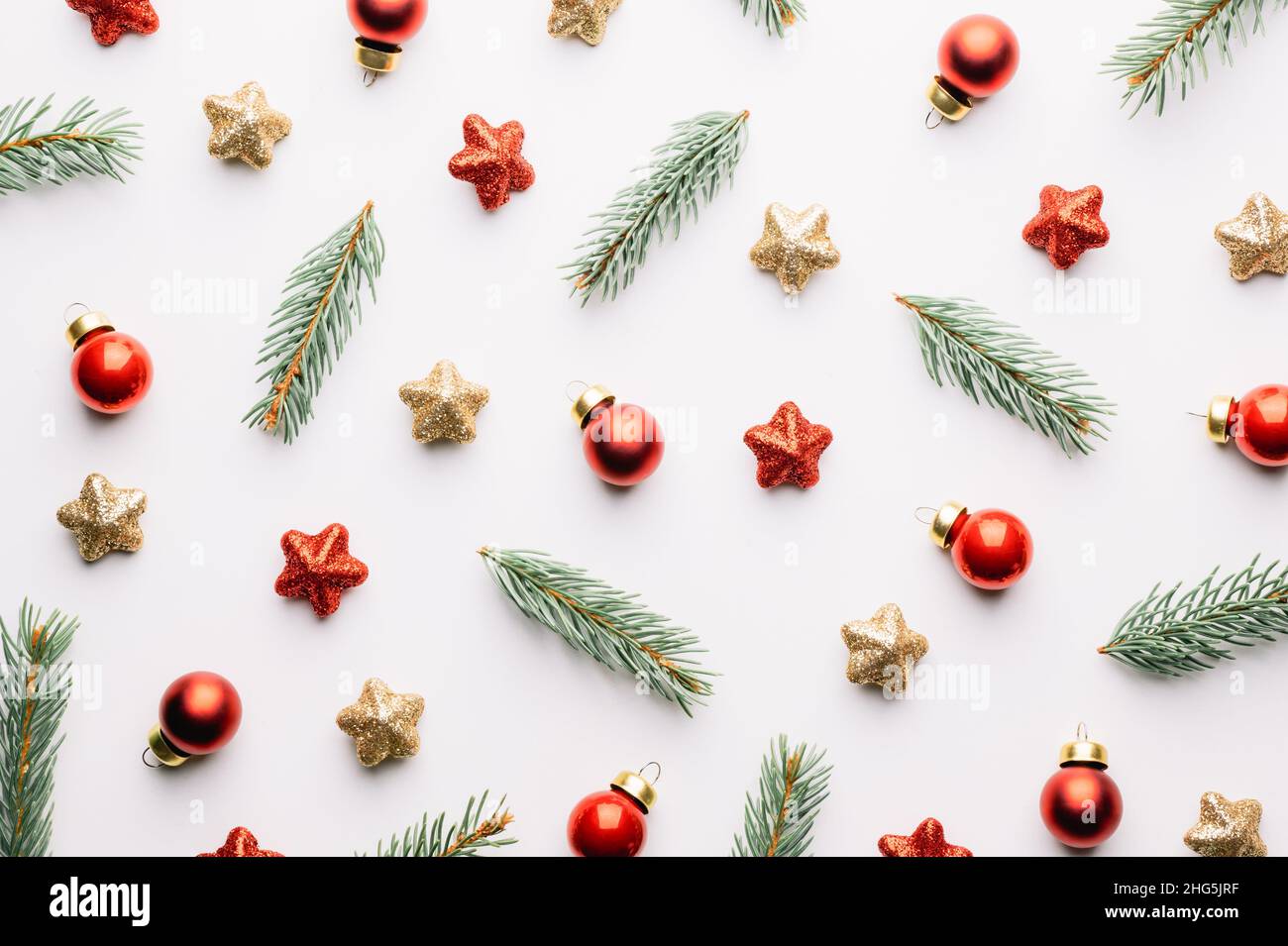 Kreativer Weihnachtshintergrund mit Weihnachtskugeln, Kiefernzweigen, roten und goldenen Sternen Dekorationen auf weißem Hintergrund. Flach liegend, Draufsicht, Kopierbereich Stockfoto