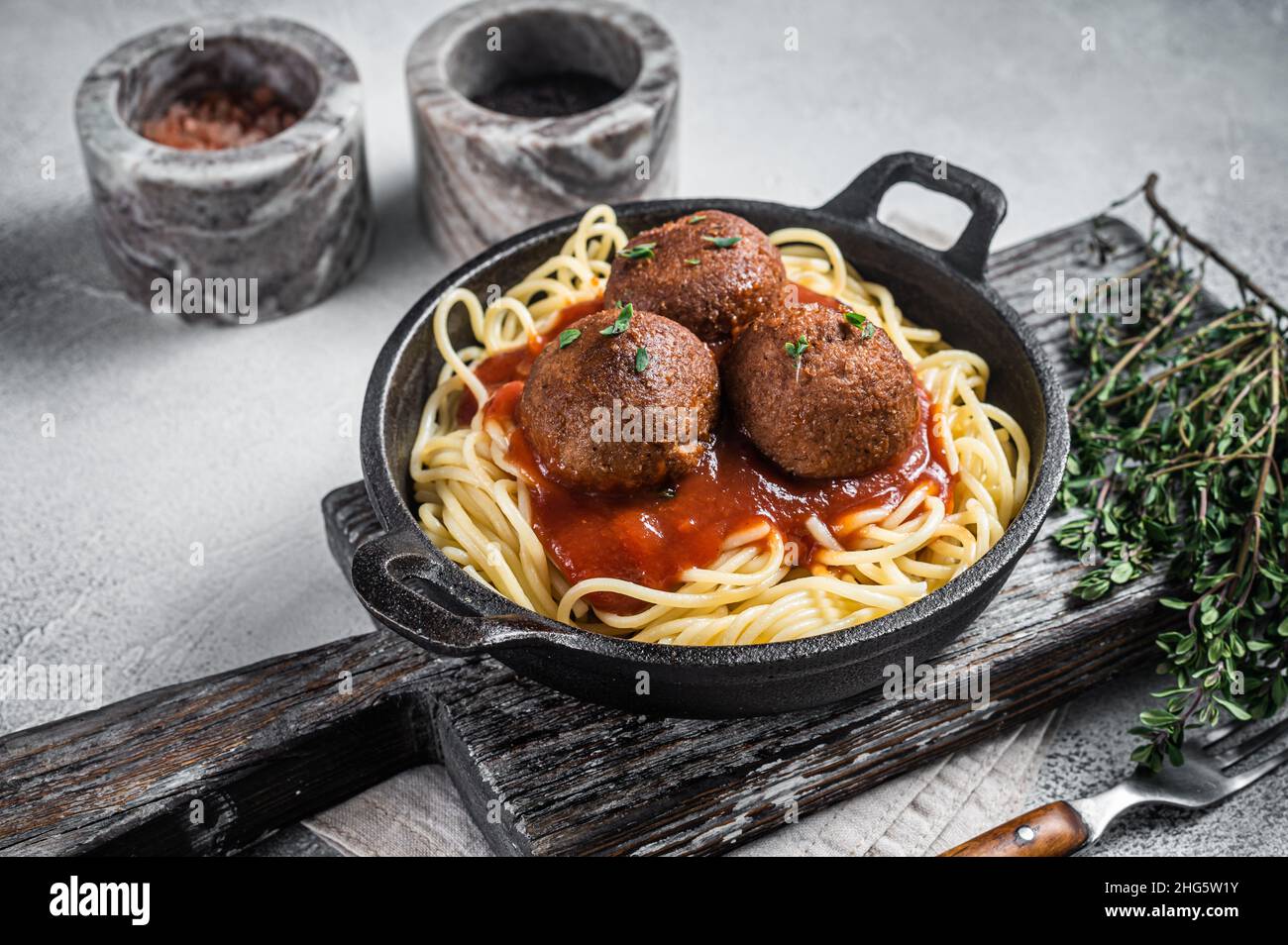 Vegane Tomatenpasta mit Fleischbällchen auf pflanzlicher Basis in einer Pfanne. Weißer Hintergrund. Draufsicht Stockfoto