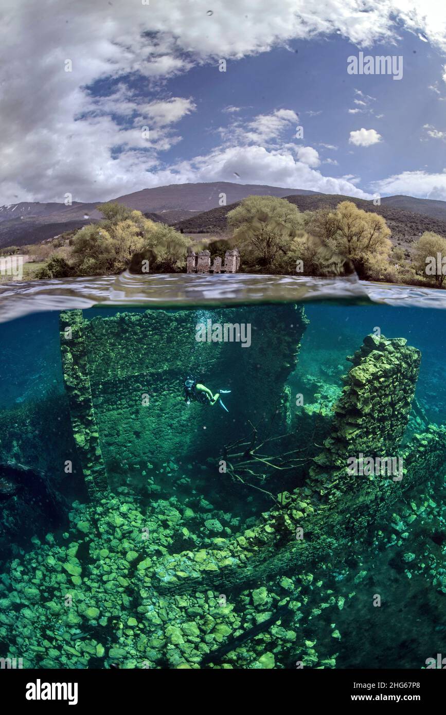 Ein Split Shot von Taucher aus Capodacqua See, in den Abruzzen (Italien) genommen. Eine halbe Kuppel im Wasser zeigt die untergetauchten Ruinen der mittelalterlichen Mühlen, Stockfoto