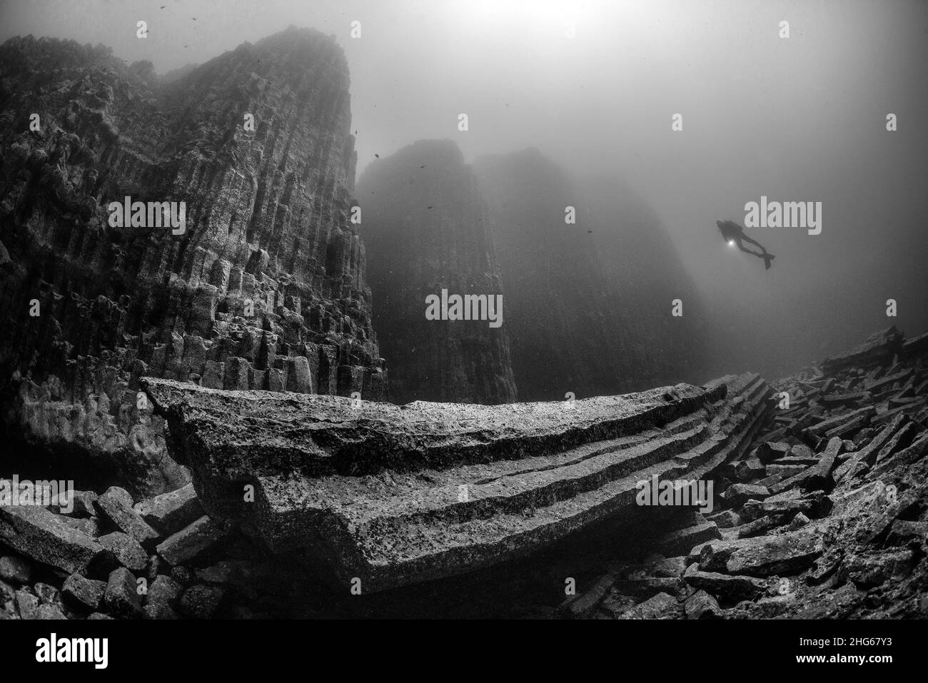 Schwarz-Weiß-Aufnahme eines Tauchers auf dem Meeresboden der Insel Teneriffa, den wilden Basaltenlandschaften des Tauchstandortes Las Torres, Kanarische Inseln, Spanien Stockfoto