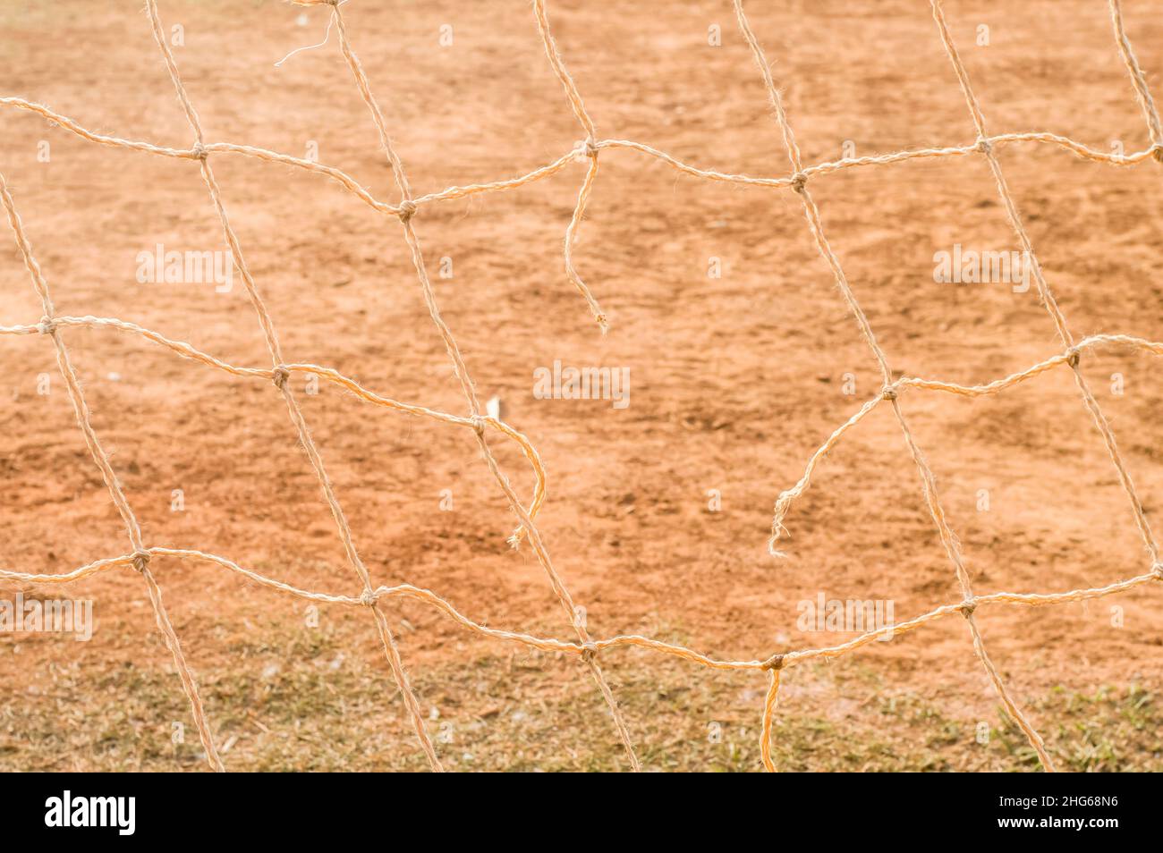 Textur mit Fußballnetz, Tageslicht, Gras, Erde im Hintergrund. Stockfoto