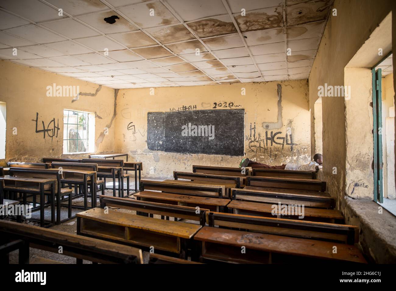 Maiduguri, Nigeria. 24th. November 2021. Ein Junge sah, wie er in einem leeren Klassenzimmer der Moduganari-Grundschule auf einem Schreibtisch lag.der Nordosten von Nigeria erlebt seit 2009 einen Aufstand, der zu 2,4 Millionen Vertriebenen geführt hat und etwa die Hälfte der Schüler die Schulbildung verlassen musste. (Foto: Sally Hayden/SOPA Images/Sipa USA) Quelle: SIPA USA/Alamy Live News Stockfoto