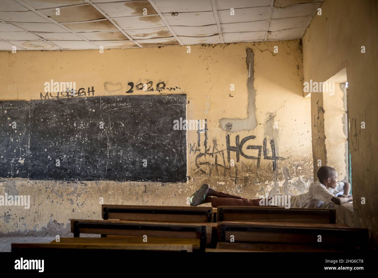 Maiduguri, Bundesstaat Borno, Nigeria. 24th. November 2021. Ein Junge sah, wie er in einem leeren Klassenzimmer der Moduganari-Grundschule auf einem Schreibtisch lag.der Nordosten von Nigeria erlebt seit 2009 einen Aufstand, der zu 2,4 Millionen Vertriebenen geführt hat und etwa die Hälfte der Schüler die Schulbildung verlassen musste. (Bild: © Sally Hayden/SOPA Images via ZUMA Press Wire) Stockfoto