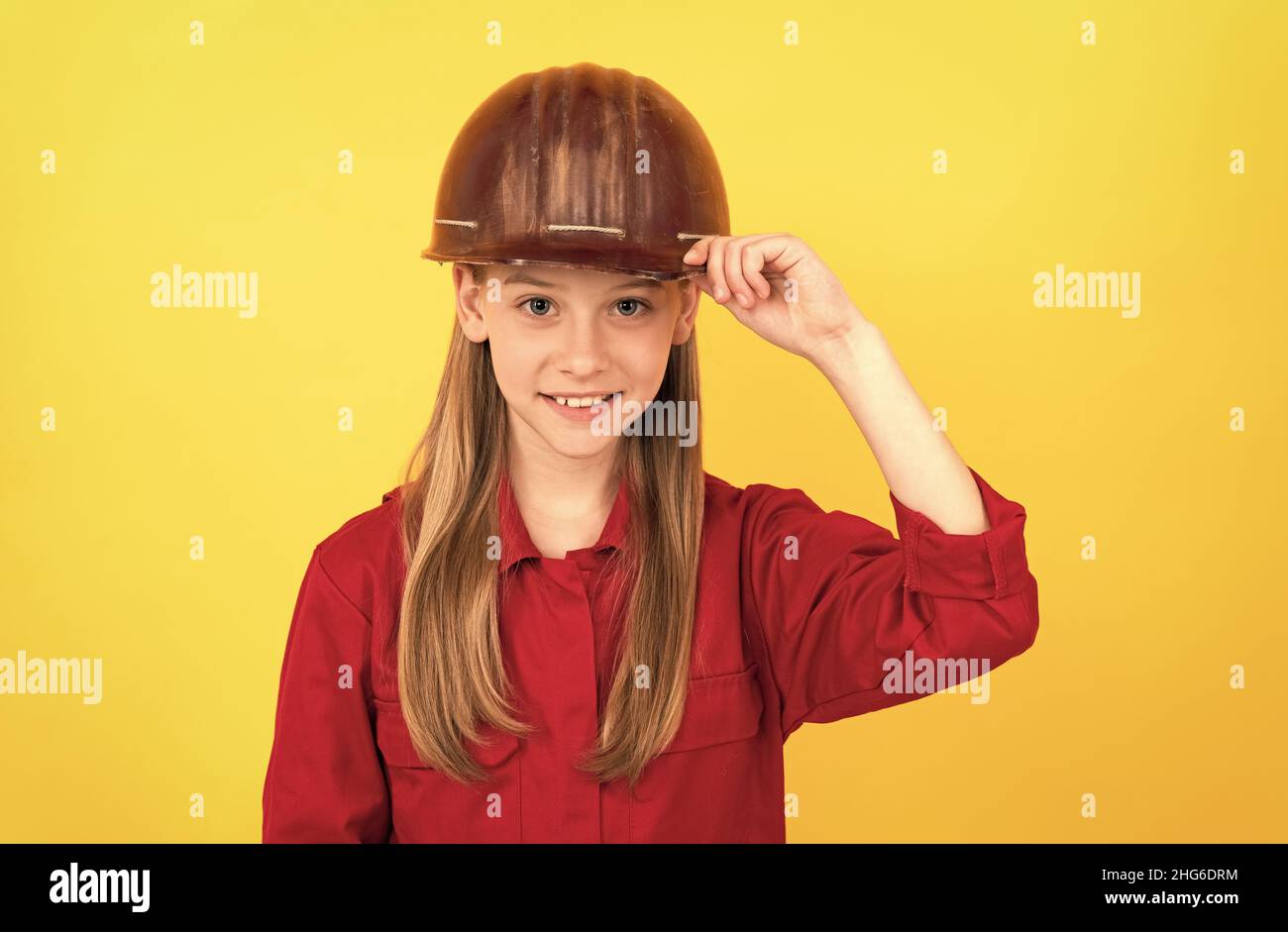 Zukünftige Karriere von Teenager-Mädchen in Helm-Builder mit Konzept der kindlichen Entwicklung, glücklichen Tag der Arbeit Stockfoto