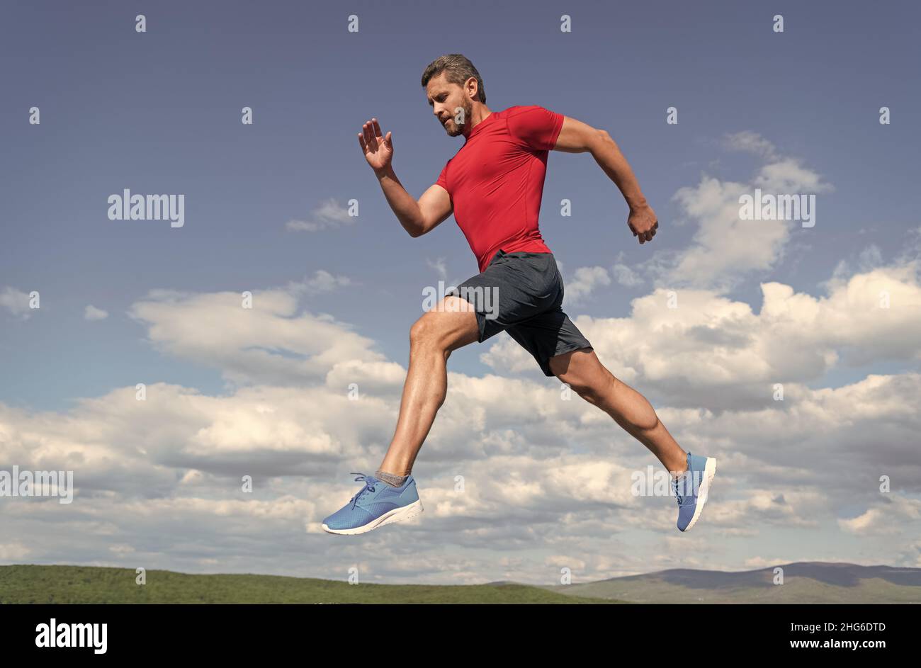 Sportler Mann Läufer laufen zum Erfolg oder springen hoch auf Himmel Hintergrund, Sport Stockfoto