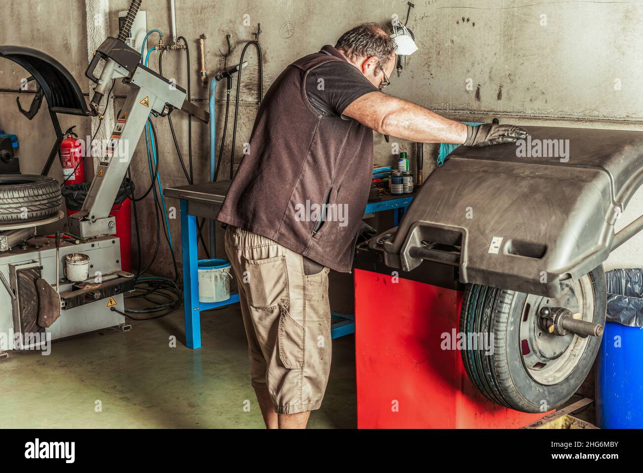 Mechaniker, der ein Rad mithilfe von Elektrowerkzeugen repariert, um ein Rad zu balancieren Stockfoto