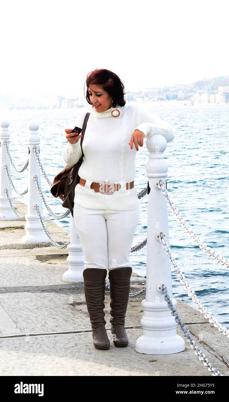 Eine hübsche Türkin, die auf der Uferpromenade an der Uskudar-Küste entlang der Bosporus-Meerenge auf der asiatischen Seite Istanbuls, Türkei, spazierengeht. Stockfoto