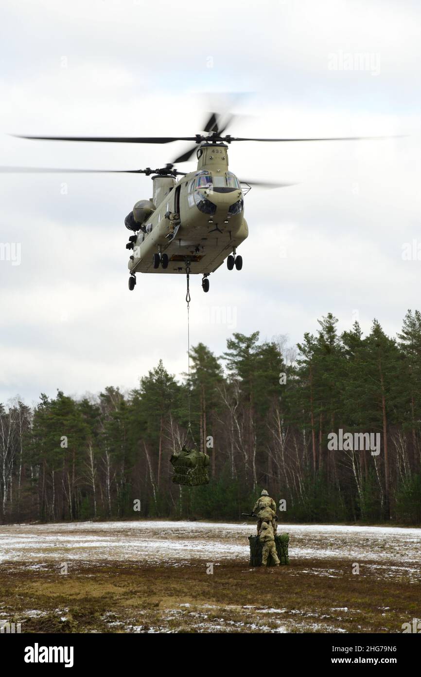 US-Soldaten, die der Comanche-Truppe, 1st Squadron, 2D Cavalry Regiment, zugewiesen sind, führen während einer situativen Trainingsübung (STX) auf Kaderebene im Trainingsgebiet Grafenwoehr, Deutschland, am 11. Januar 2022 Schlingentraglasoperationen mit einem CH-47 Chinook durch. (USA Armeefoto von Kevin Sterling Payne) Stockfoto