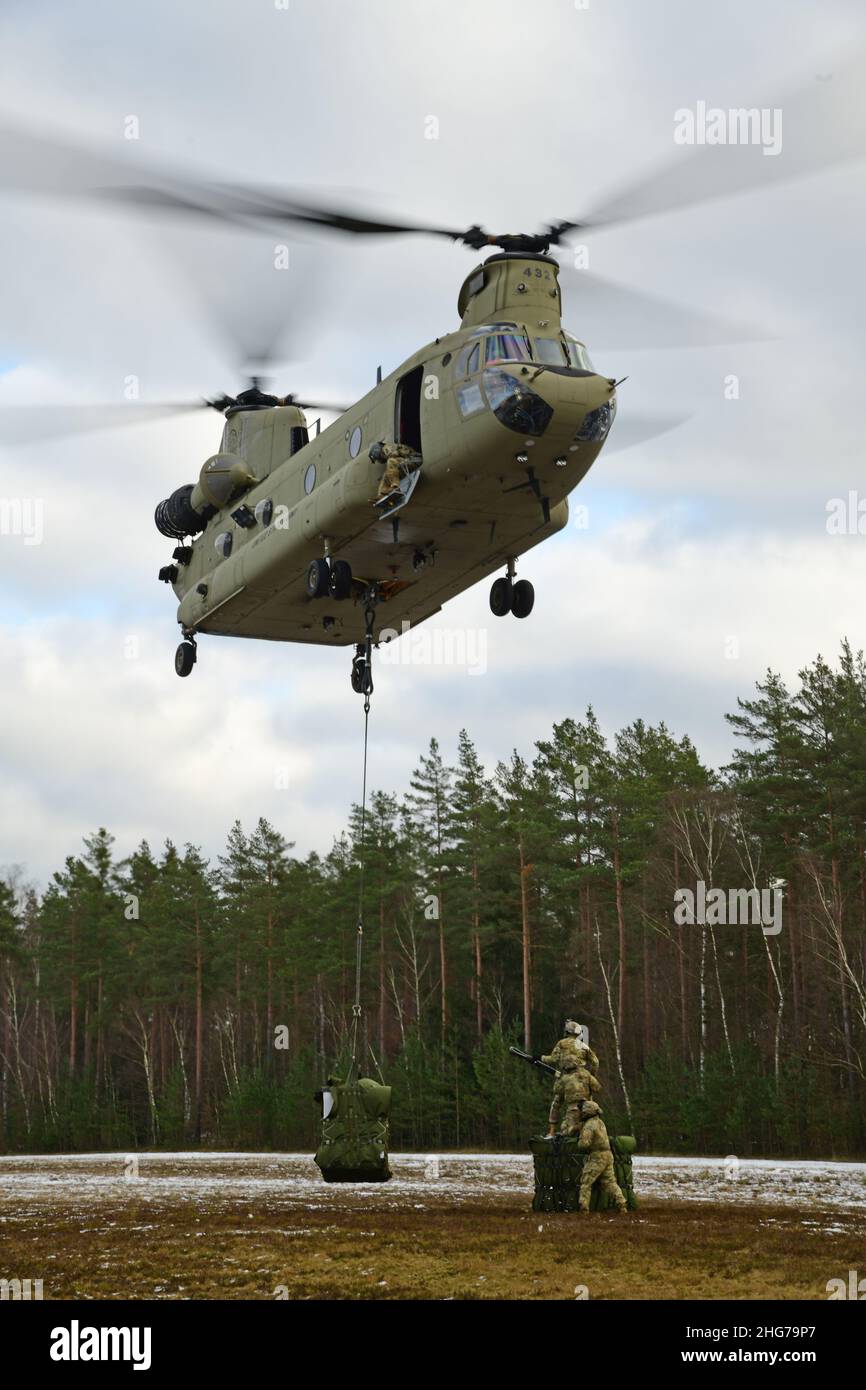 US-Soldaten, die der Comanche-Truppe, 1st Squadron, 2D Cavalry Regiment, zugewiesen sind, führen während einer situativen Trainingsübung (STX) auf Kaderebene im Trainingsgebiet Grafenwoehr, Deutschland, am 11. Januar 2022 Schlingentraglasoperationen mit einem CH-47 Chinook durch. (USA Armeefoto von Kevin Sterling Payne) Stockfoto
